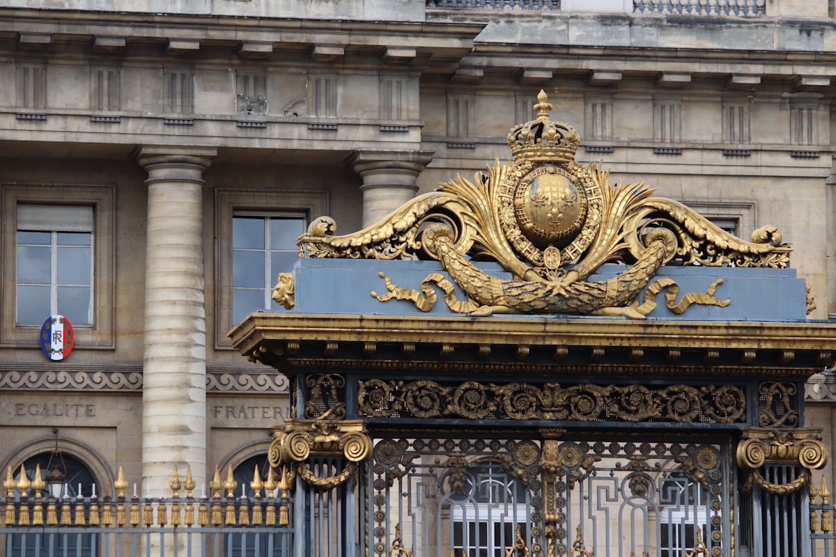 Ornate golden gate with classical building background