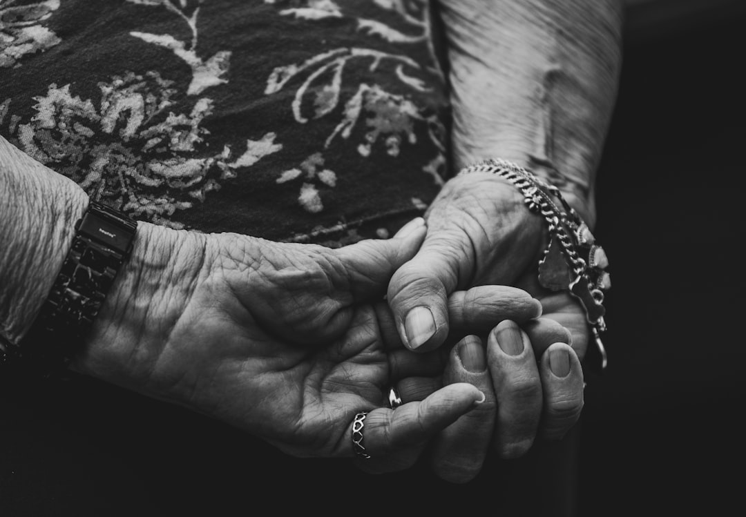 Tendresse entre générations: une femme âgée et une jeune femme se tenant la main, évoquant la transformation bijoux de grand-