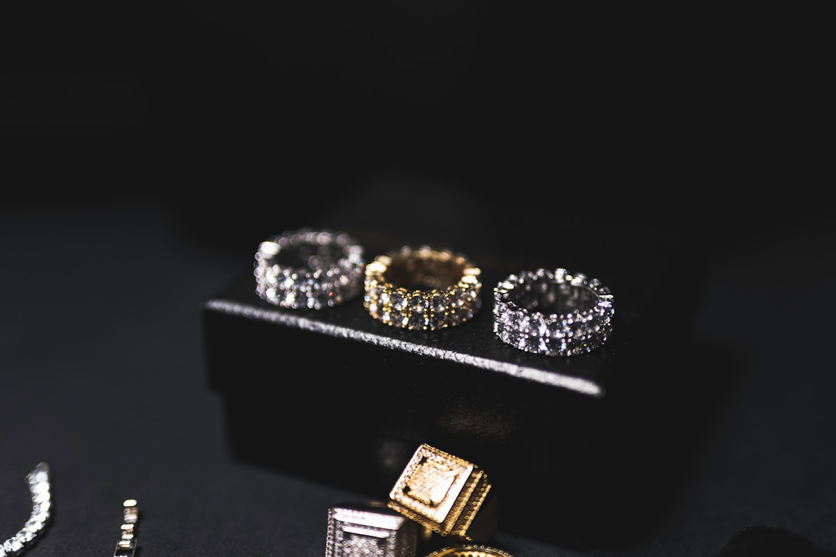 Bagues en or et en argent ornées de diamants sur fond noir.