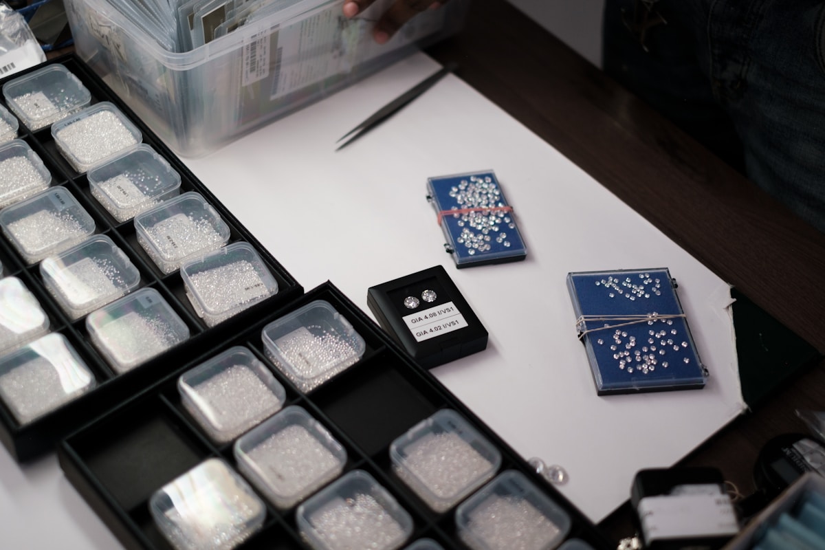 Boîtes de diamants et de pierres précieuses sur un bureau.