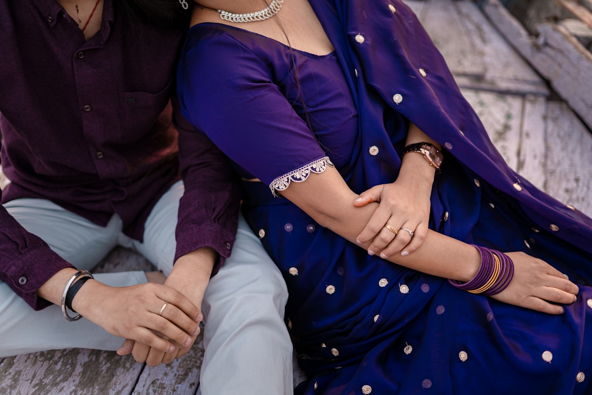 Couple en tenue traditionnelle indienne, étreinte intime, bijoux et accessoires colorés.