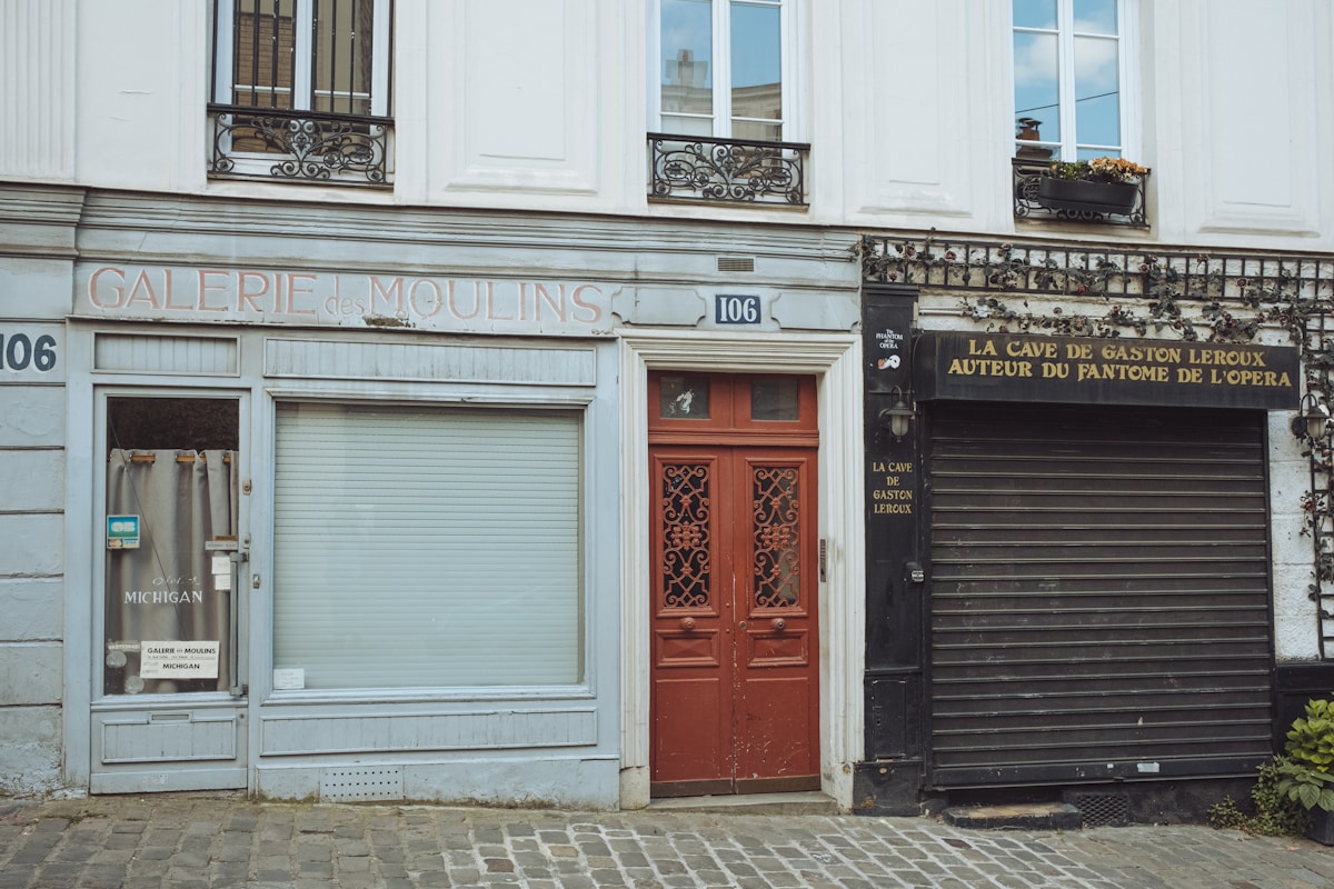 Façade de bâtiment parisien avec galerie d'art et cave de Gaston Leroux.