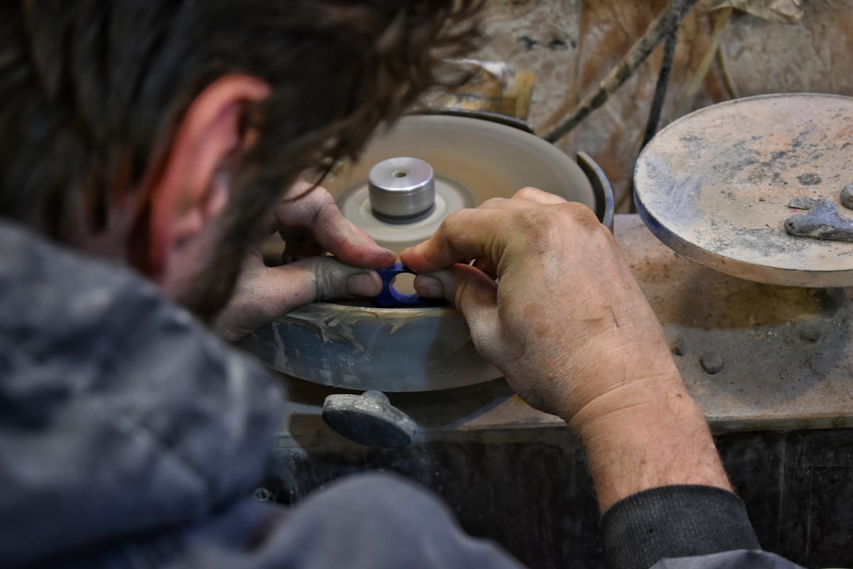 Un homme en chemise noire à manches longues tenant une tasse en céramique bleue et blanche.