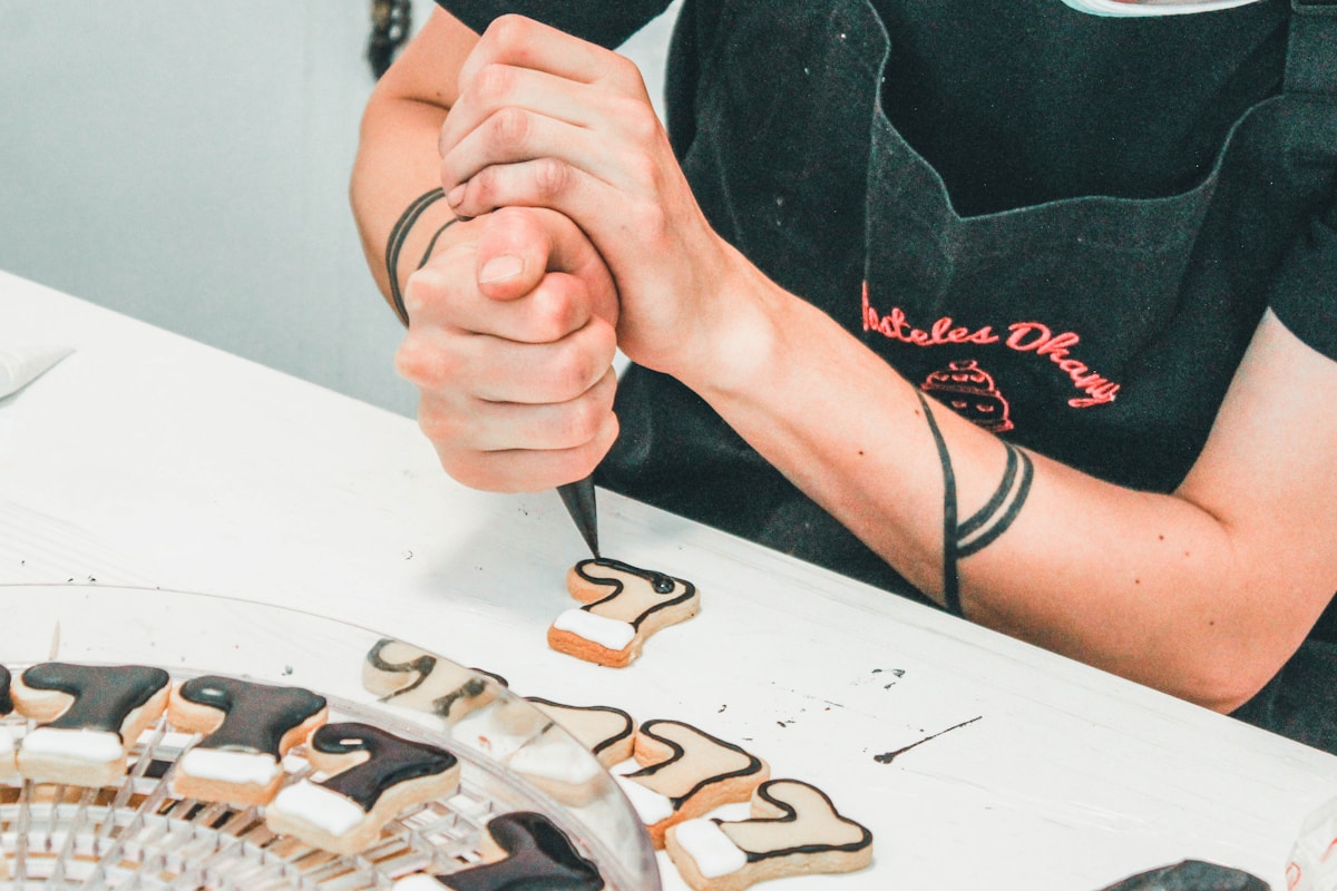 Personne tatouant un symbole sur un papier avec des outils de tatouage.