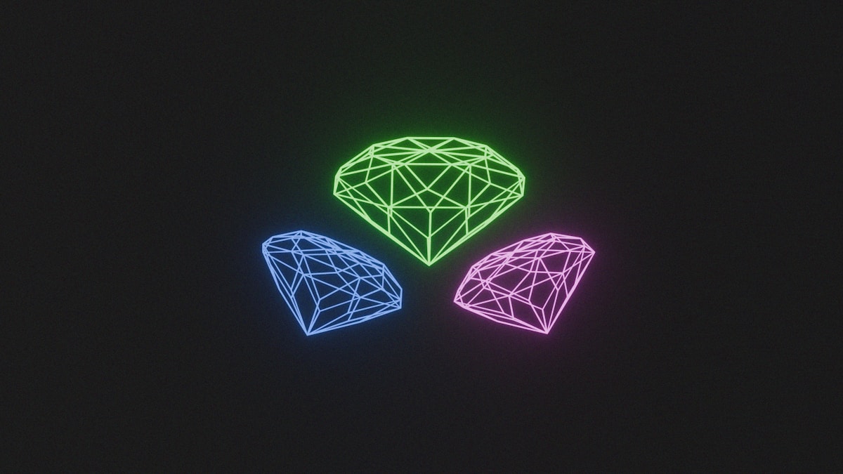 Trois diamants lumineux de couleurs différentes sur fond noir.