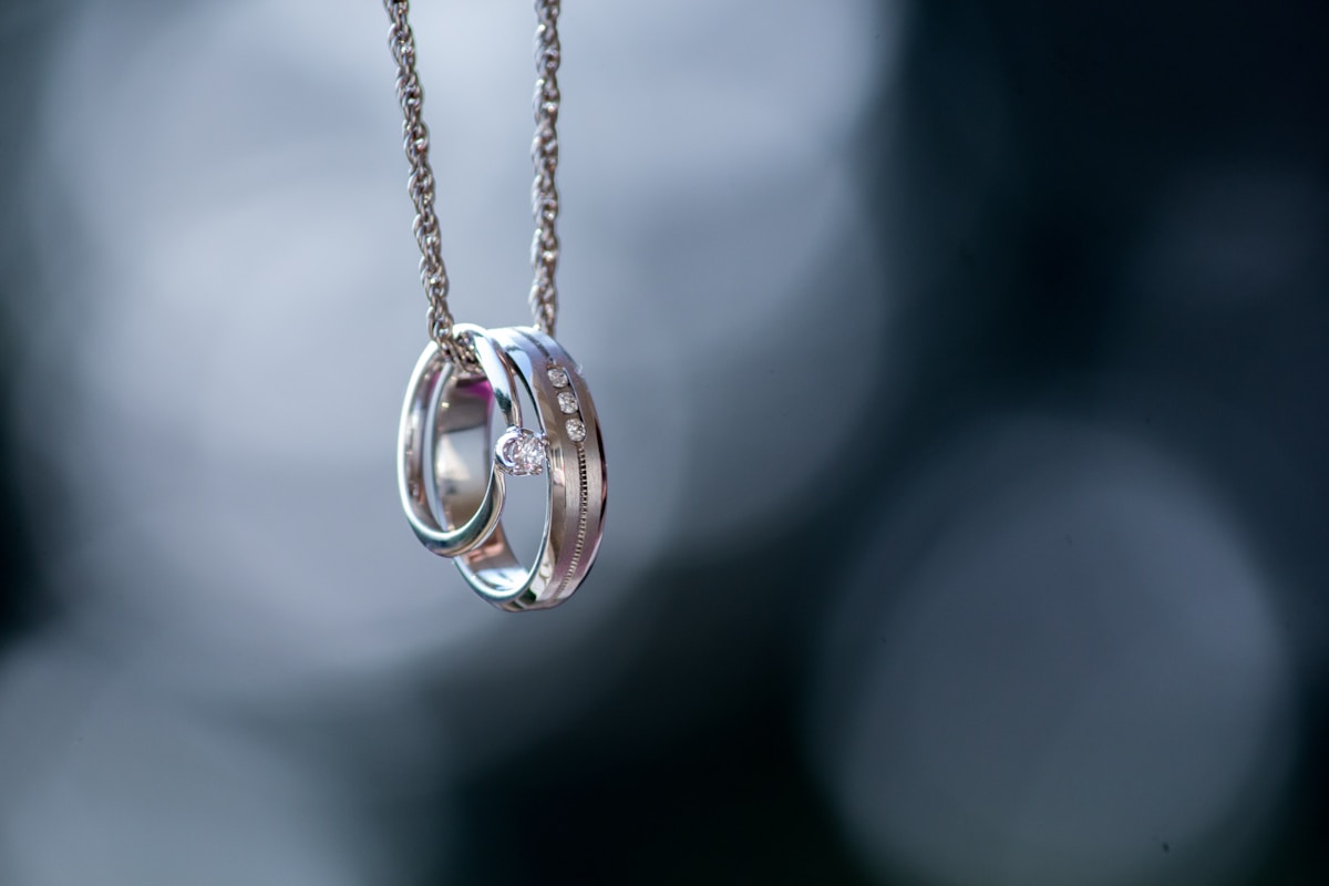 Pendentif en argent avec anneaux entrelacés et diamants.