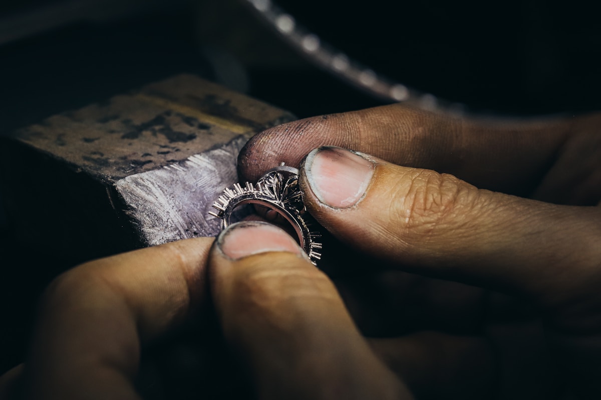 Bague de fiançailles en métal sombre sur un fond sombre.