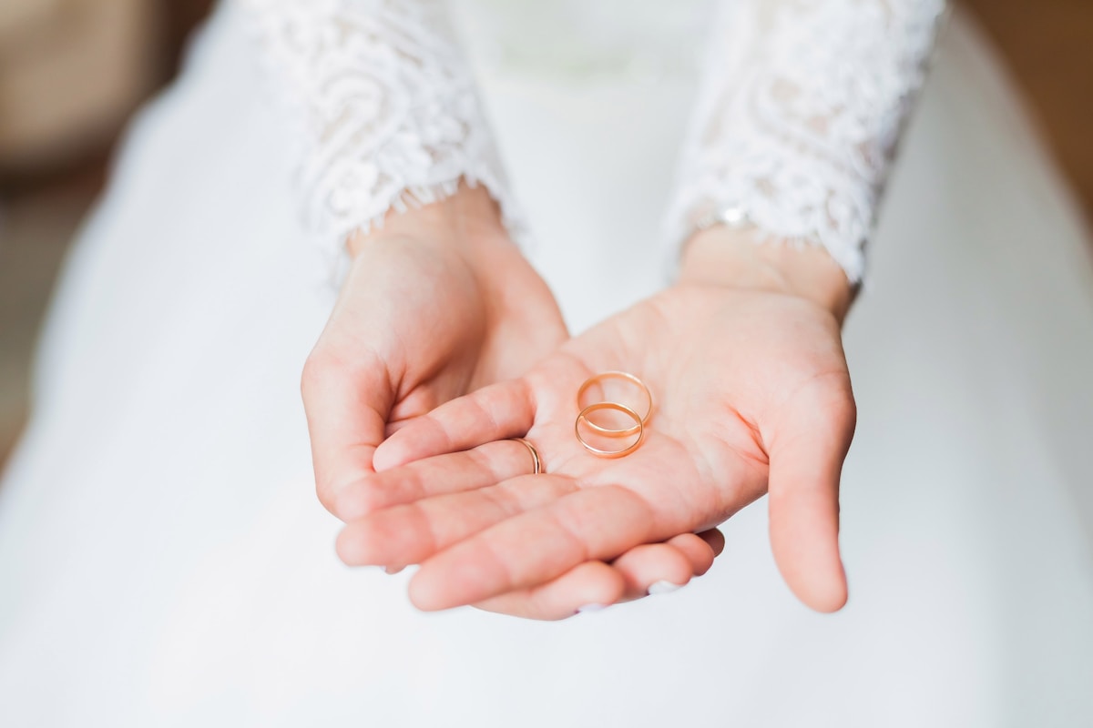 Mains tenant des alliances de mariage, symbole d'engagement et d'union.