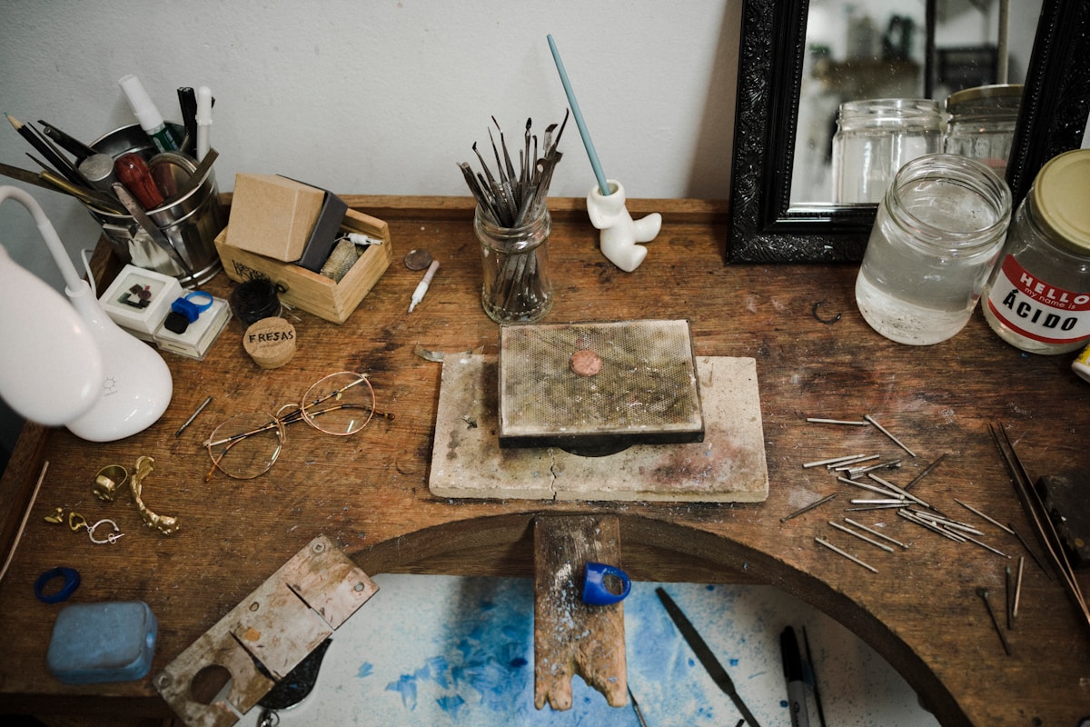 Atelier d'artiste encombré avec outils, pinceaux et matériaux.