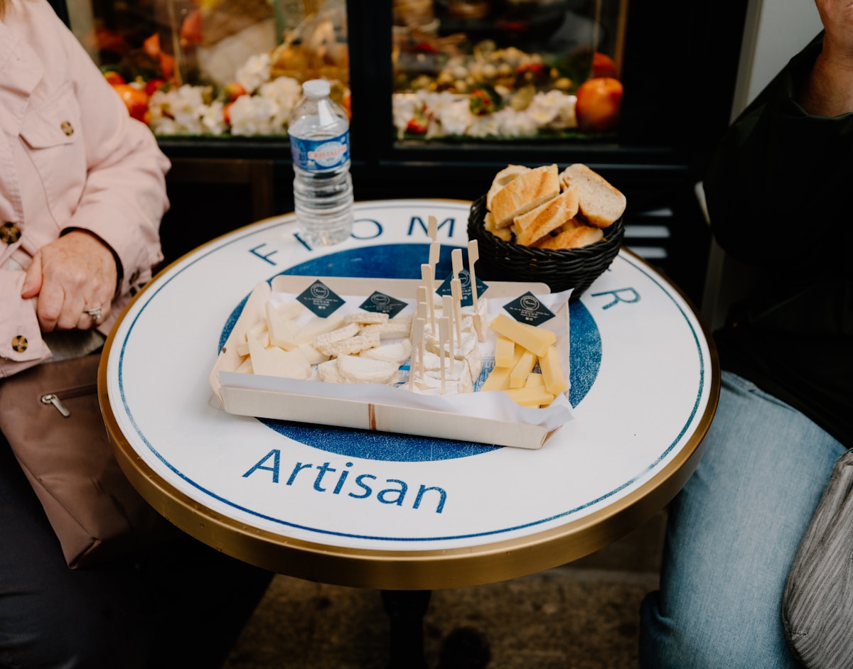 Plateau de fromages et de pain sur un comptoir Artisan.