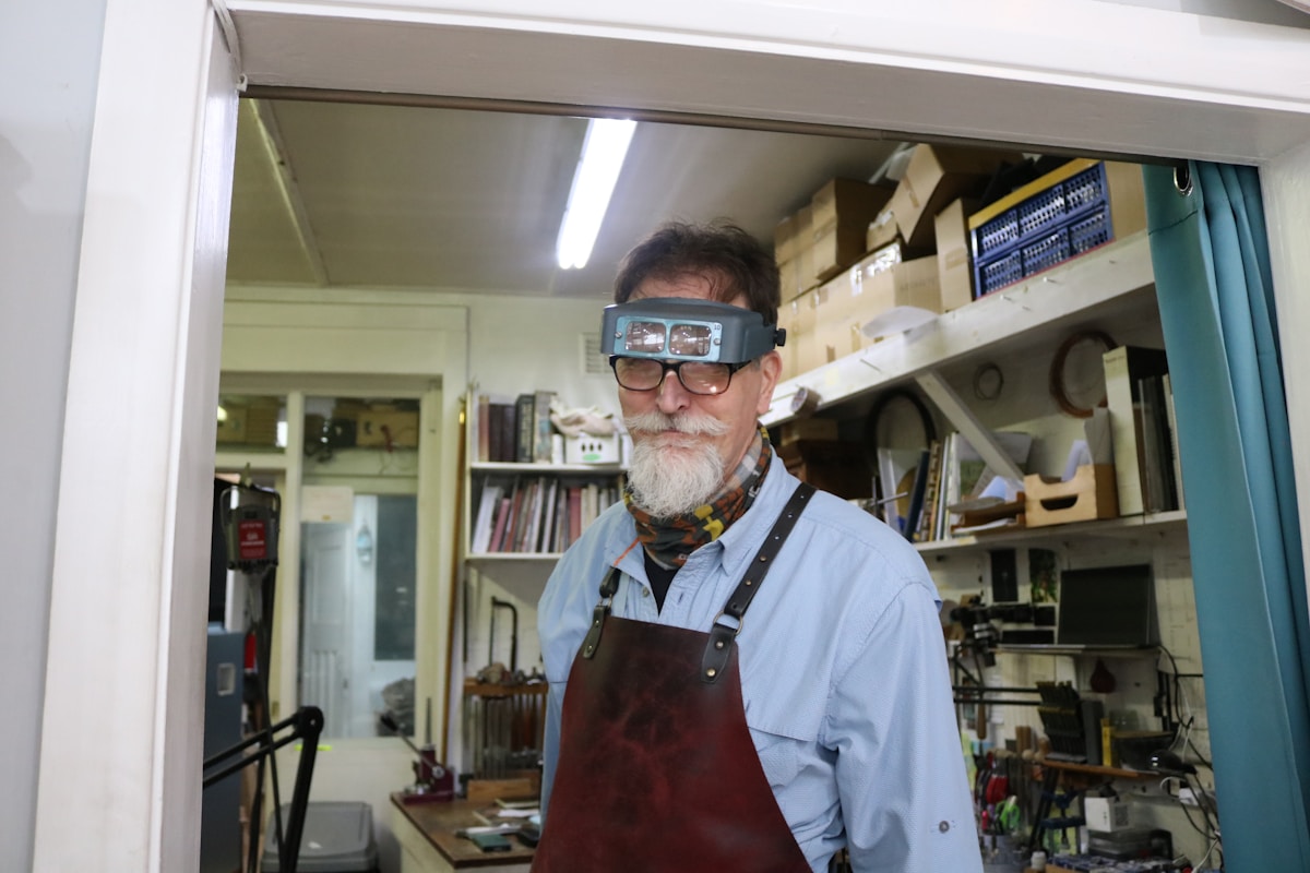 Homme âgé portant des lunettes de soudage dans un atelier.