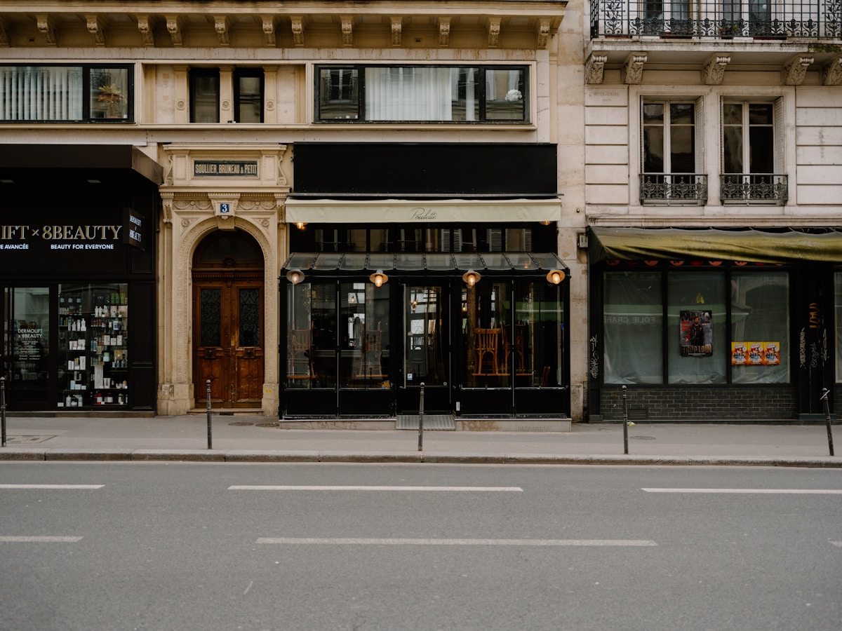 Bâtiment parisien historique avec devanture de restaurant et boutique.