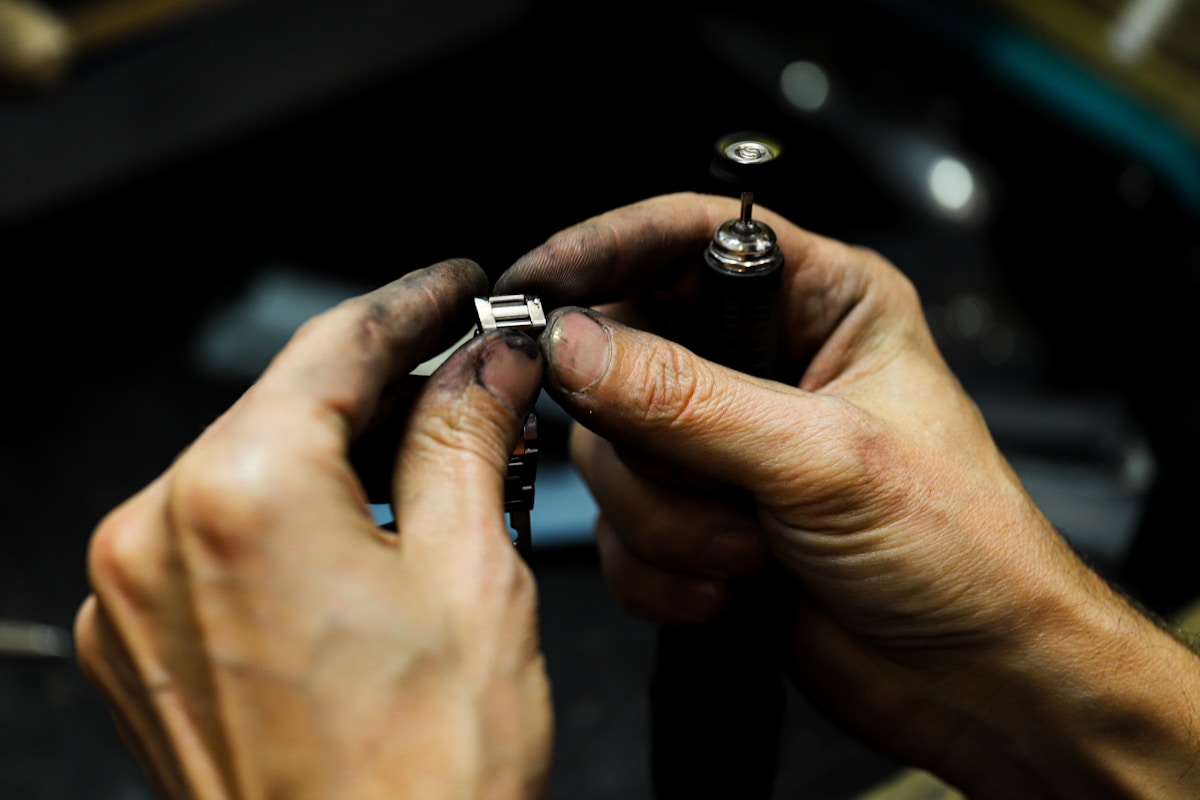 Mains réparant un mécanisme de montre de poche.