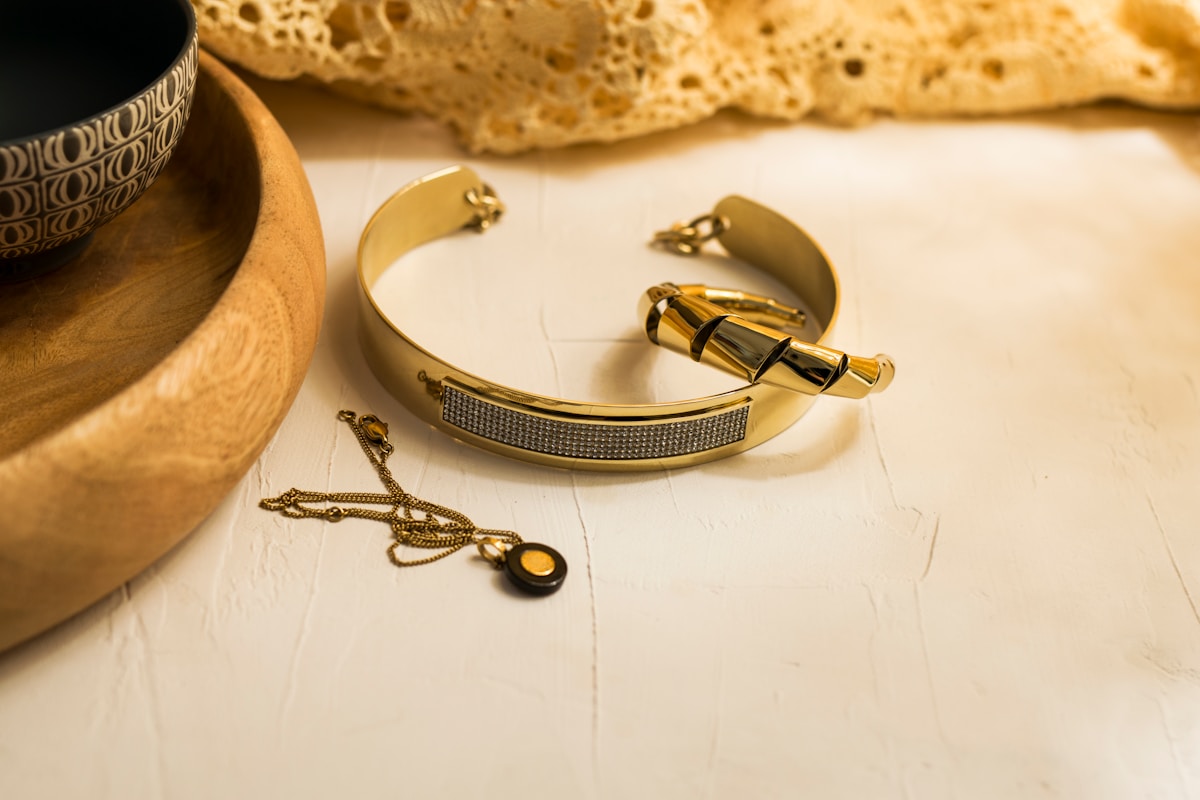 Bijoux dorés, collier, bracelet, tasse, pain.
