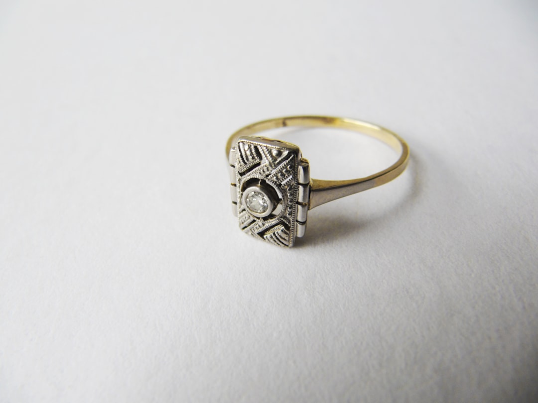 restaurer bague ancienne vs neuve - a diamond ring sitting on top of a white surface