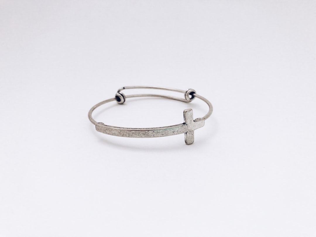 bracelet s steel - closeup photo of silver-colored cross bangle
