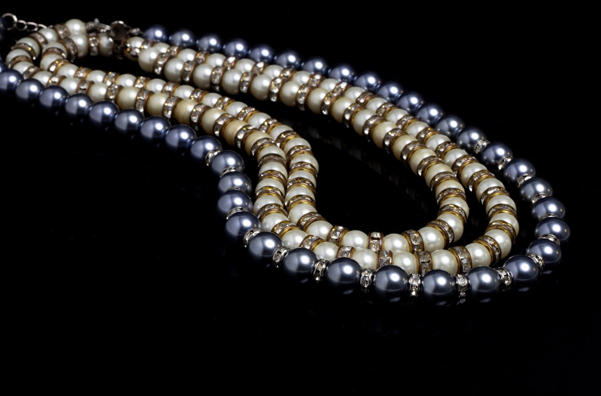 Collier de perles et de pierres précieuses sur fond noir.