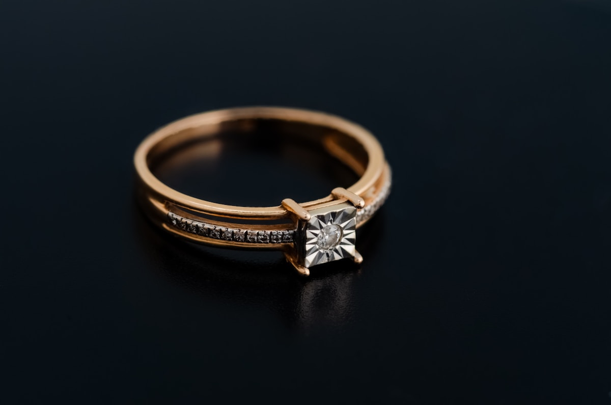 Bague en or rose avec diamant central et pierres sur les côtés.