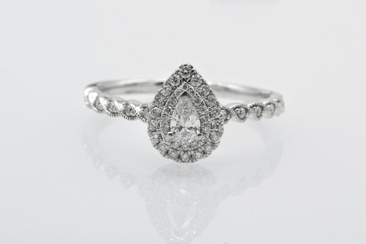 Bague de fiançailles en or blanc avec un diamant en forme de poire.