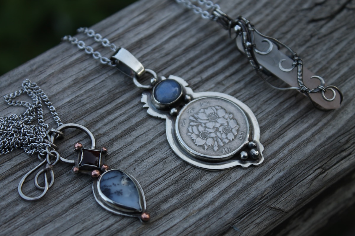 Collier en métal avec pendentifs et pierres précieuses.