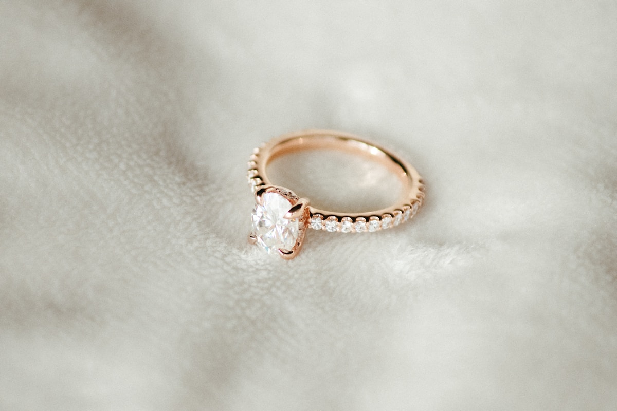 Bague de fiançailles en or rose avec un diamant central.