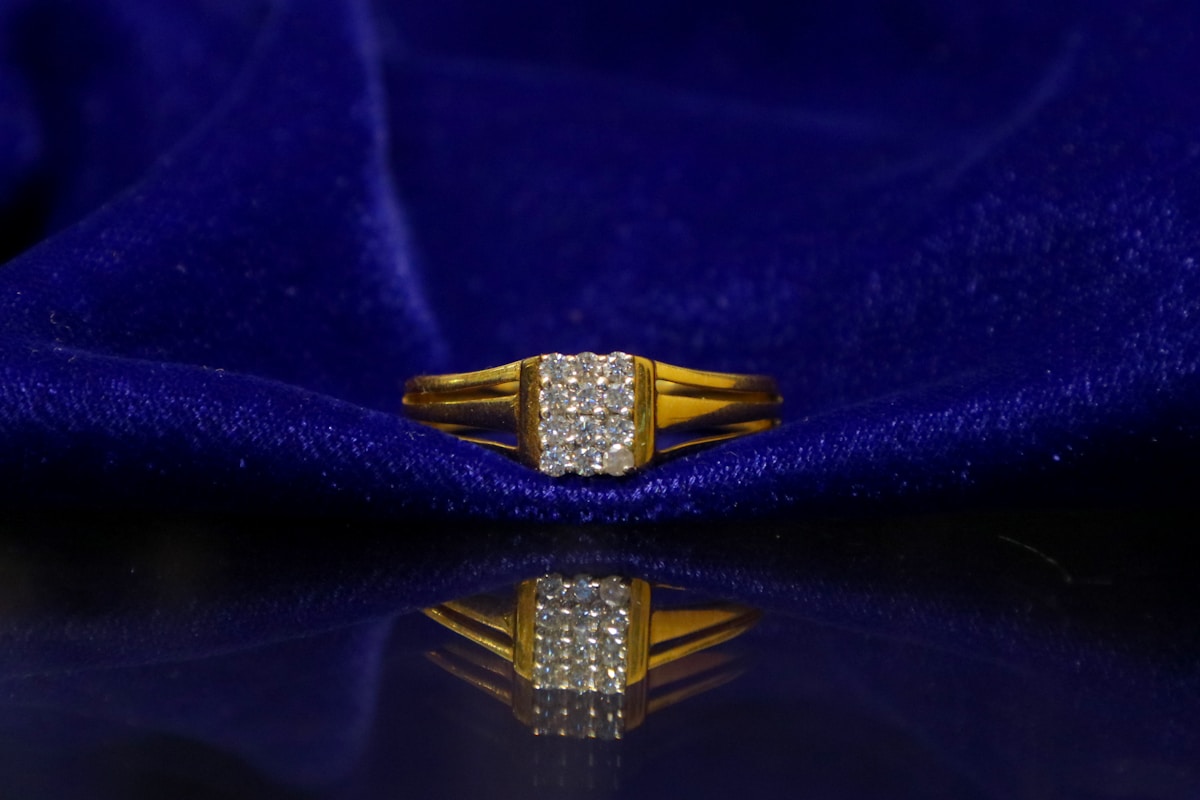 Bague en or avec diamants sur fond bleu sombre.