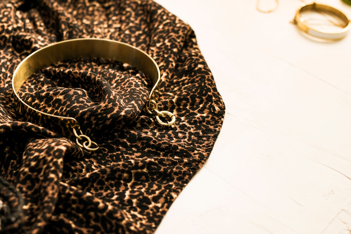 Boucle d'oreille dorée sur un motif léopard.