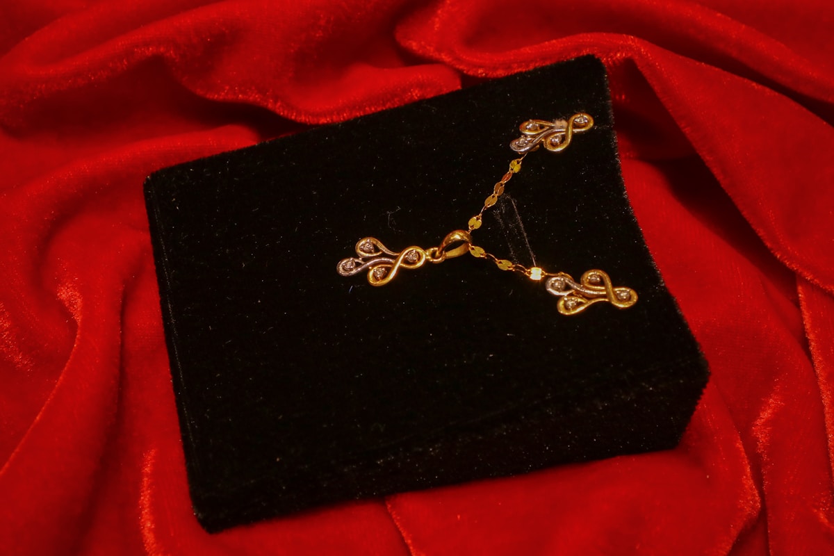 Boucles d'oreilles dorées sur un écrin noir velours.
