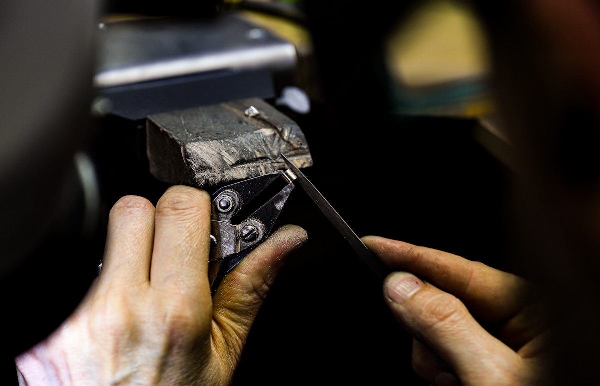 Mains réparant un équipement mécanique avec un outil.