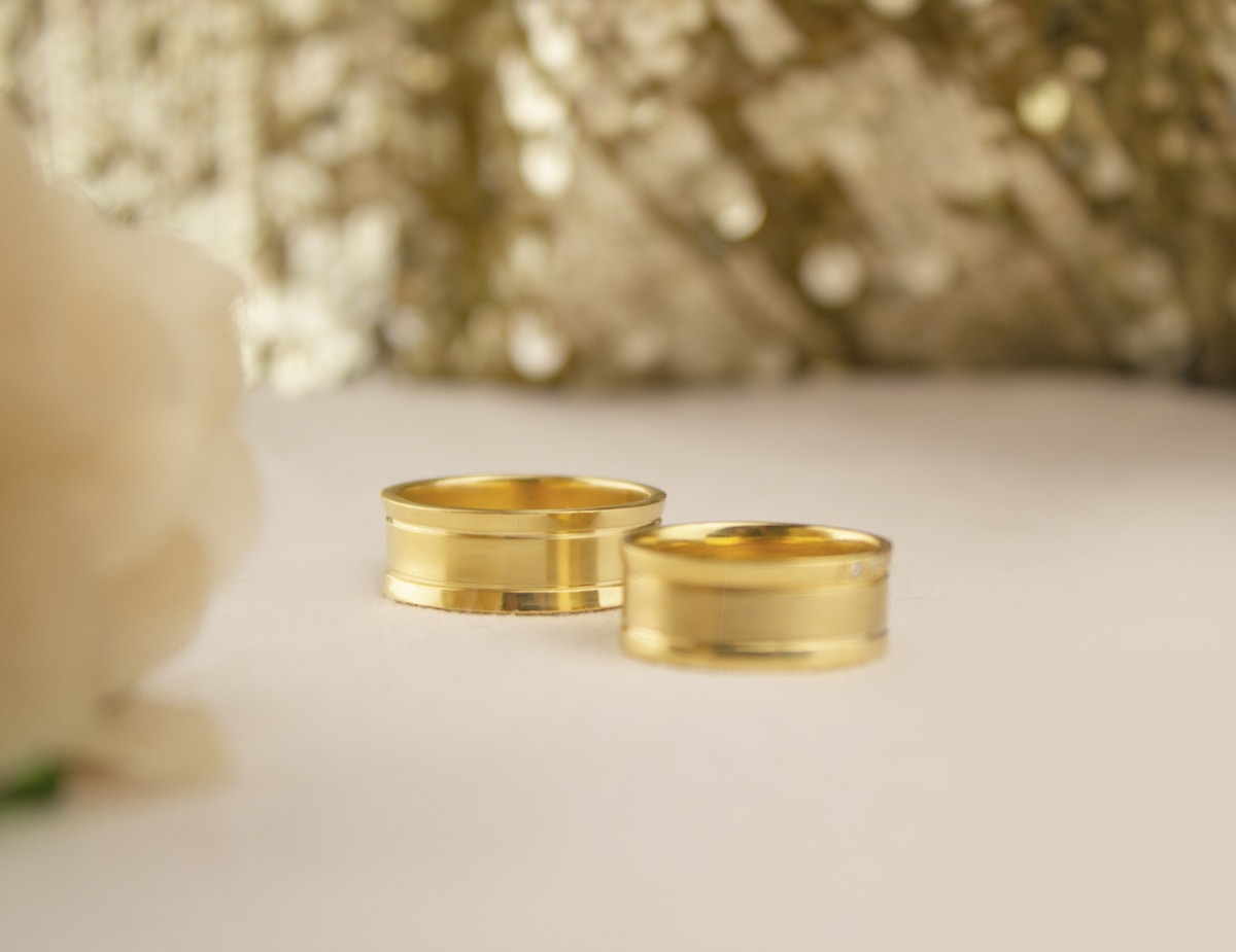 Deux anneaux de mariage en or brillants sur un fond flou.