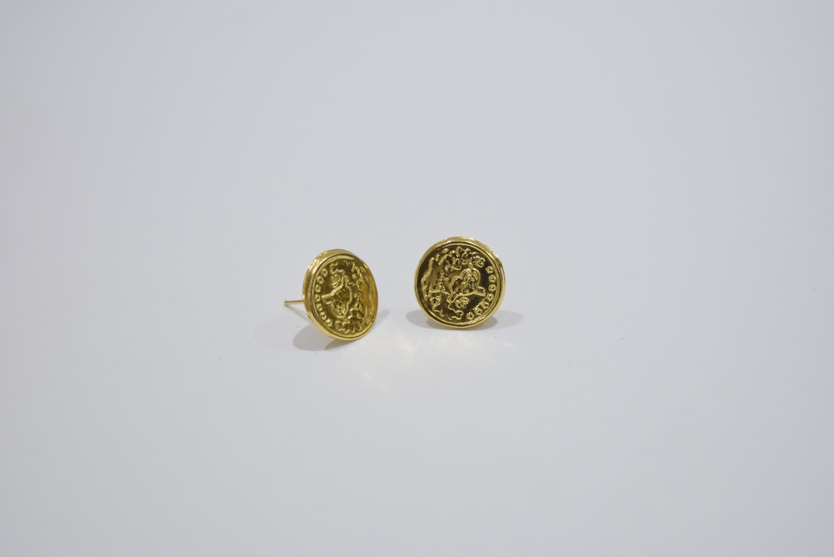 Deux pièces de monnaie dorées avec des motifs gravés.
