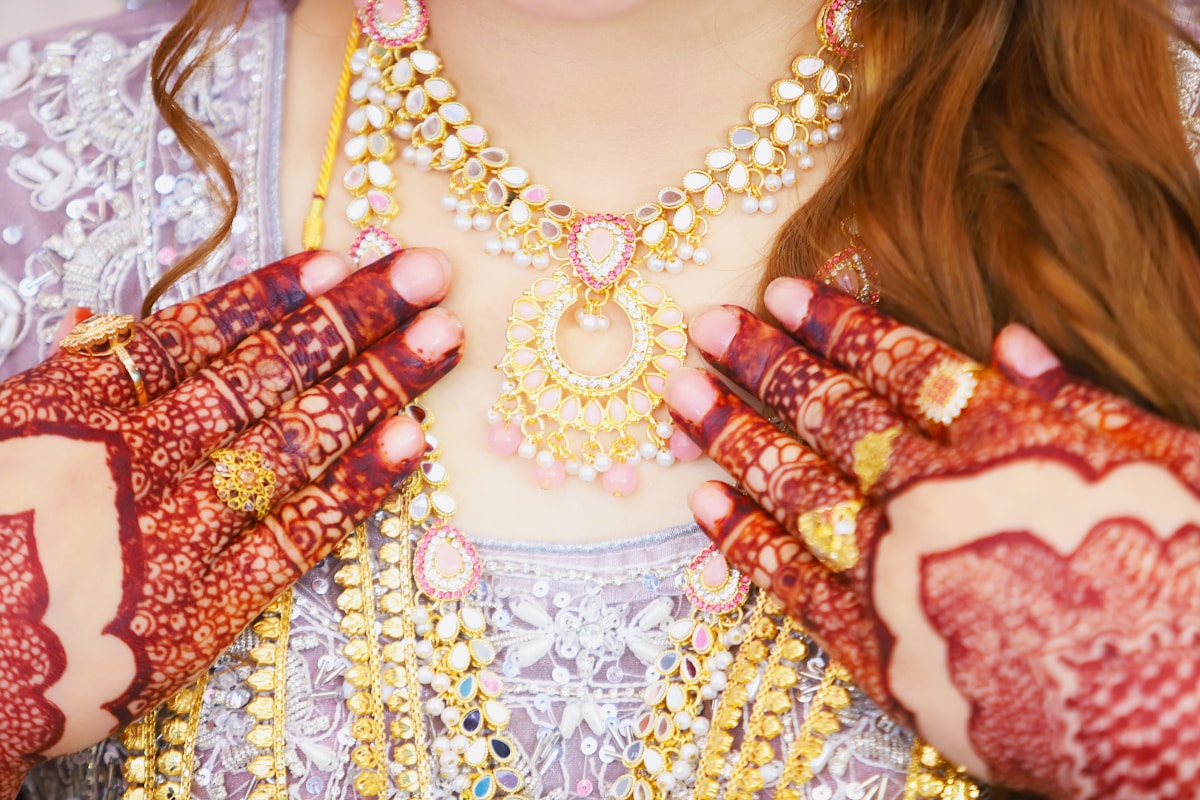 Bijoux dorés et colorés, motifs ethniques, mains ornées de henné.