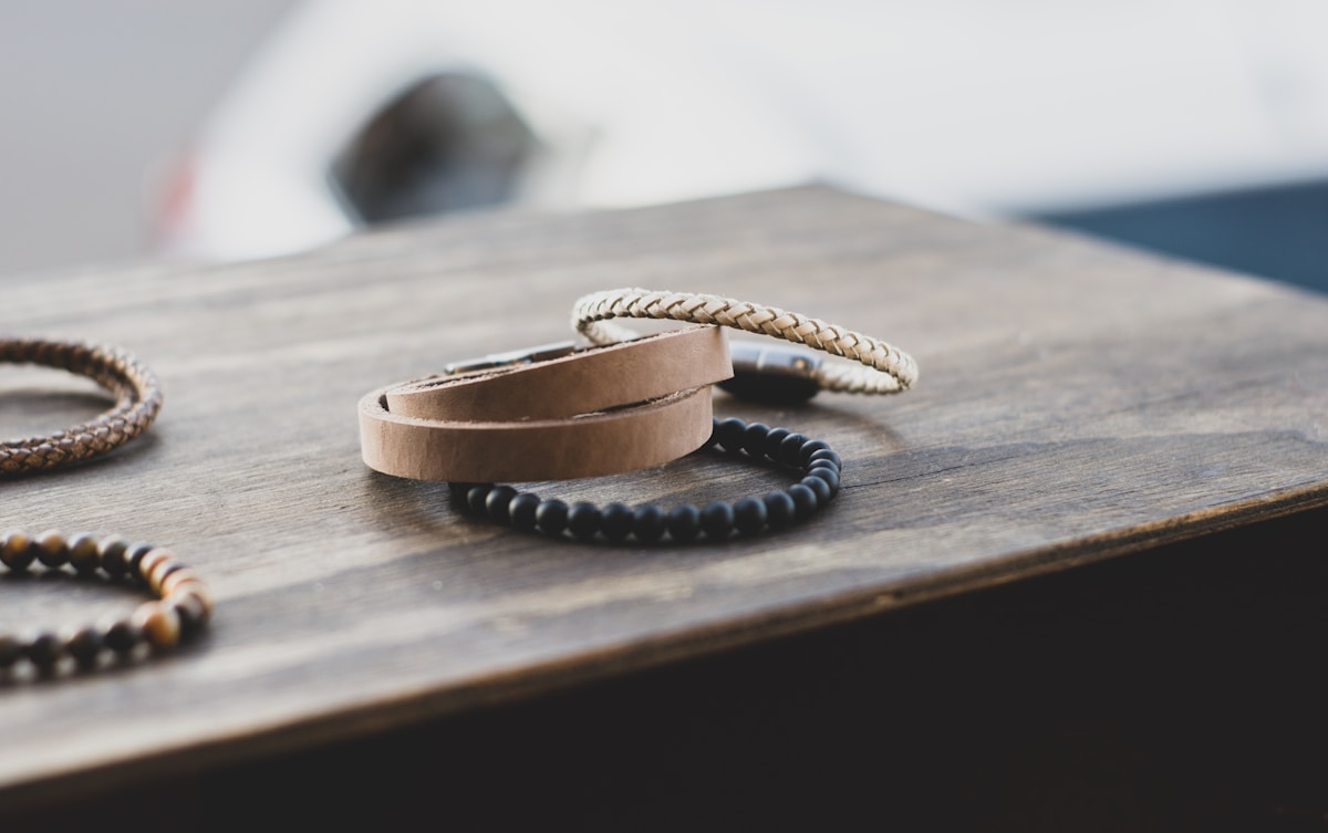 Bracelets en cuir et perles sur une surface en bois.