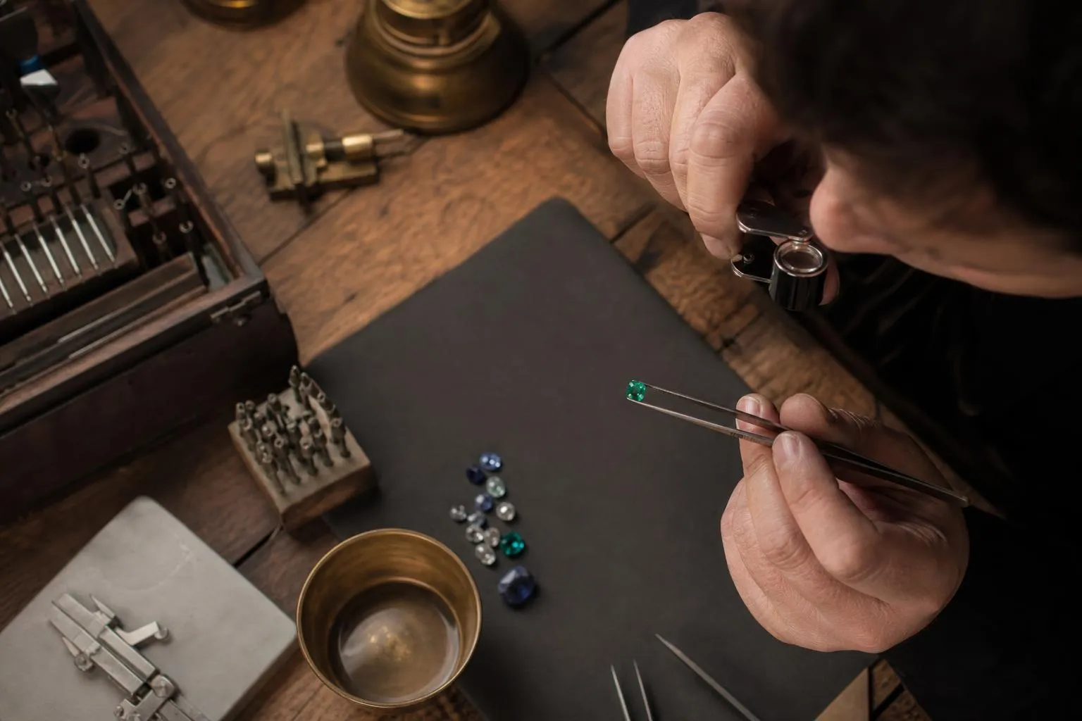 Outils de joaillerie, pierres précieuses, travail artisanal délicat.