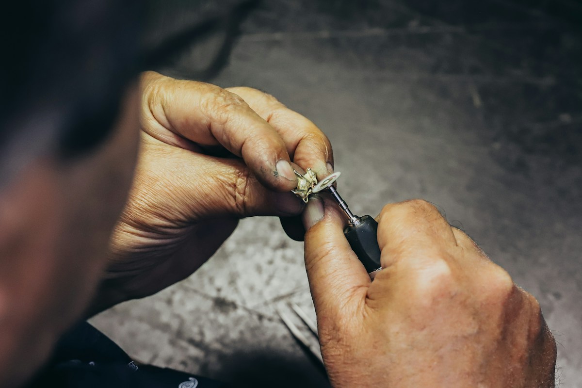 Artisan réparant un petit mécanisme avec une perceuse de précision