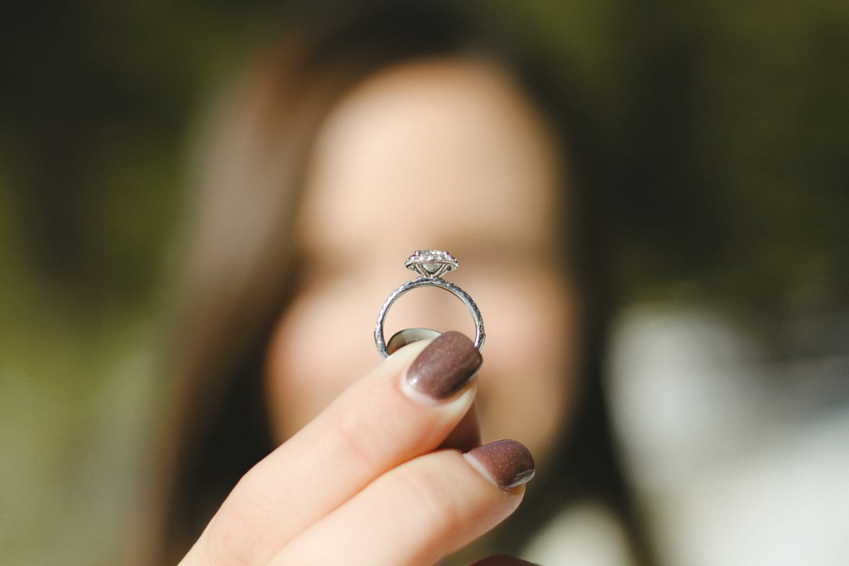 Main tenant une bague de fiançailles sertie de diamants