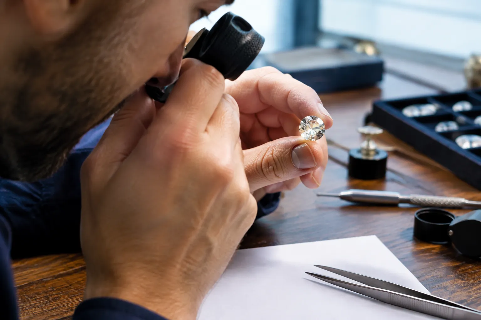 Expert examine un diamant taillé à la loupe.